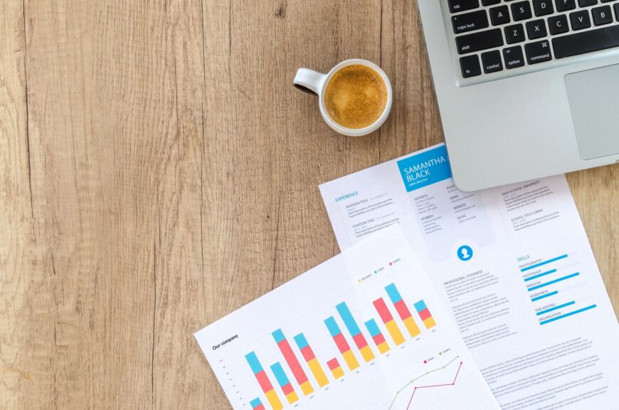 Businessperson using laptop with QuickBooks Online dashboard, showing graphs and financial data for small business optimization